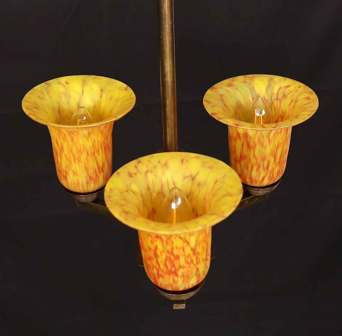 A 1930s GLC bronzed metal light fitting with three marbled amber glass shades, height 60cm. width 33cm